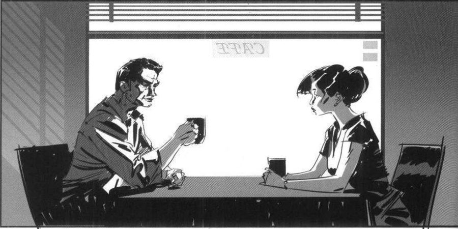 A man and a woman at a café table, both against a bright window.