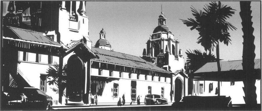 A mission-style street with a domed tower and palms by day.